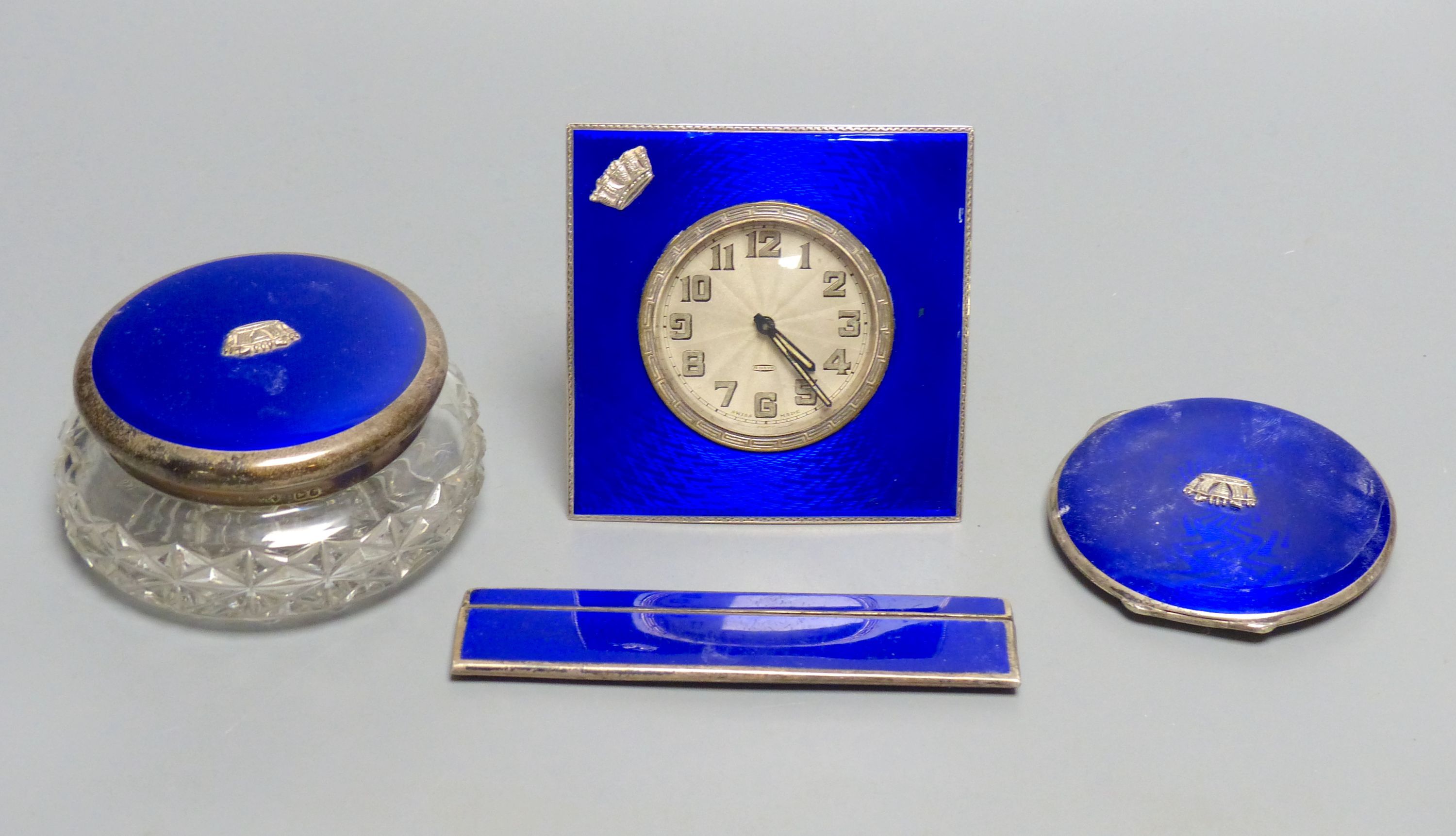 A 1930's four piece silver and blue enamel dressing table set, including , timepiece, powder jar, compact & comb,